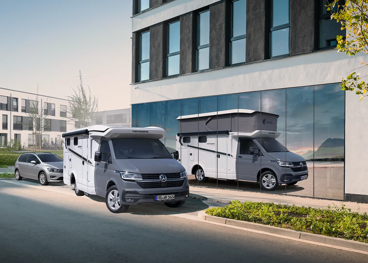 Zu sehen ist das Reisemobil Weinsberg X-Cursion CUV 500 MQ in fahrbereitem Zustand, daneben spiegelt sich dieses Reisemobil in einem Fenster, hier ist jedoch das Dach ausgefahren.